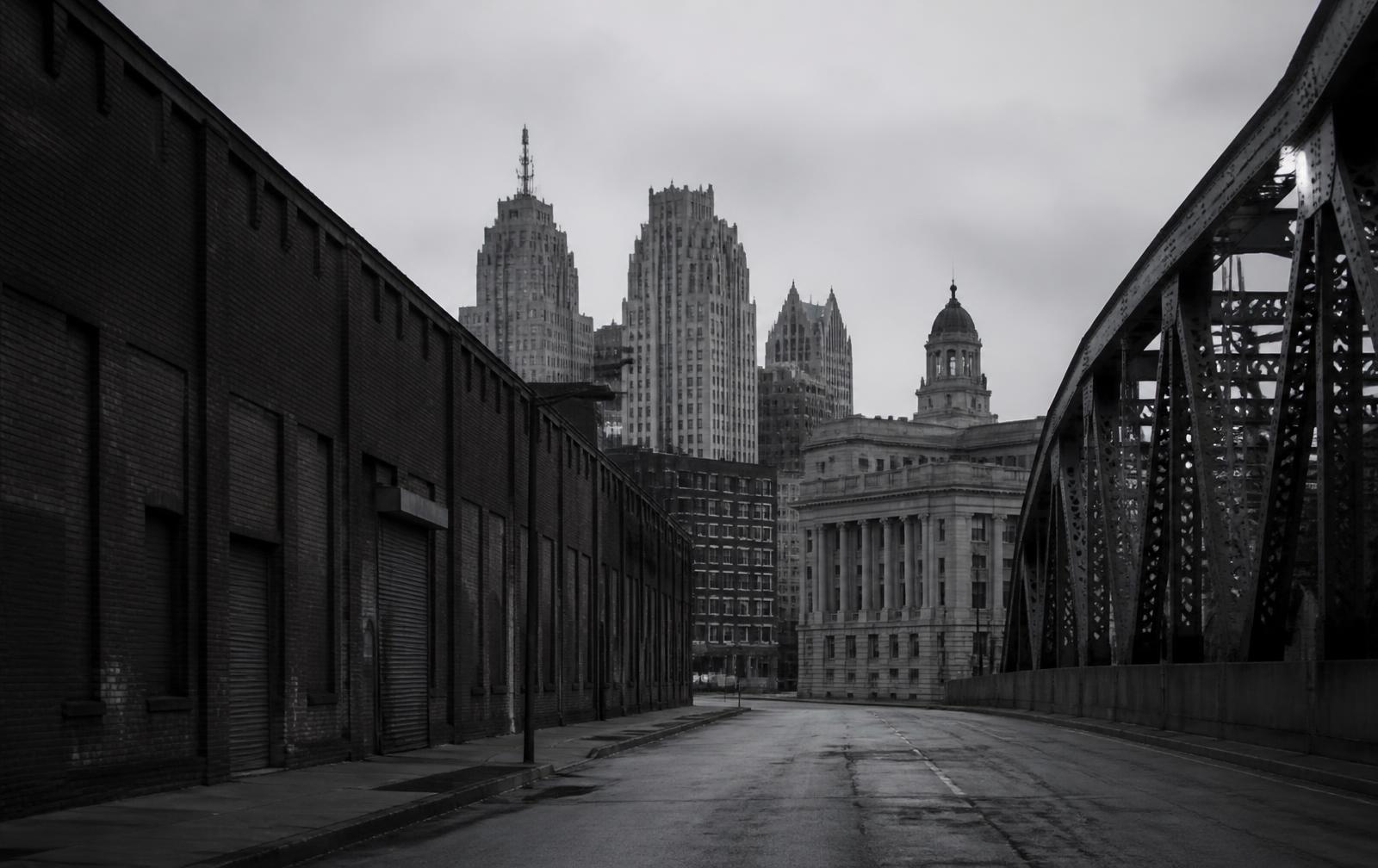 A quiet Detroit street of brick warehouses and civic buildings in grayscale